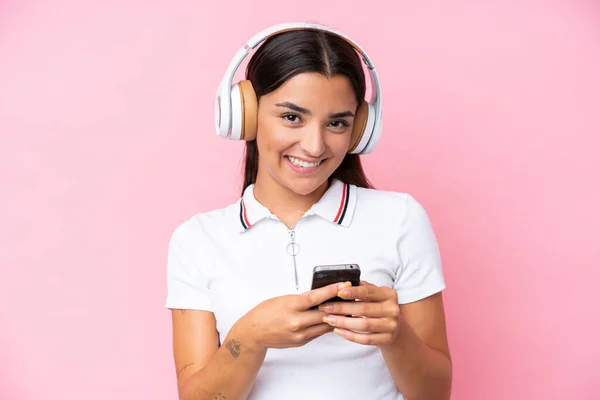 Молода Біла Жінка Ізольована Рожевому Фоні Слухає Музику Мобільним Дивиться — стокове фото