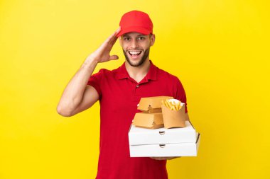 Pizza teslimatçısı, izole edilmiş arka planda pizza kutuları ve hamburgerleri alıyor.