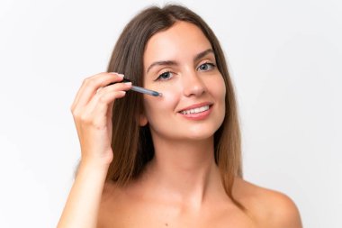 Beyaz arka planda izole edilmiş beyaz bir kadın elinde bir serum tutuyor. Portreyi kapat