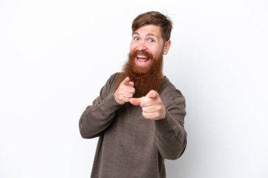 Beyaz arka planda sakallı kızıl saçlı adam şaşırmış ve ön tarafı işaret ediyor.