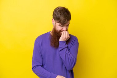 Sarı arka planda sakallı kızıl saçlı adamın şüpheleri var.