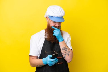 Sarı arka planda izole edilmiş önlük giyen balıkçı düşünüyor ve bir mesaj gönderiyor.