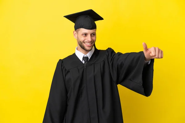 Νεαρός Απόφοιτος Πανεπιστημίου Καυκάσιος Άνδρας Απομονωμένος Κίτρινο Φόντο Κάνοντας Μια — Φωτογραφία Αρχείου