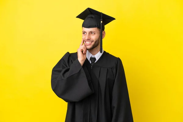 Νεαρός Απόφοιτος Πανεπιστημίου Καυκάσιος Άνθρωπος Απομονωμένος Κίτρινο Φόντο Σκέφτεται Μια — Φωτογραφία Αρχείου