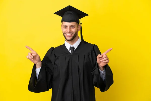 Νεαρός Απόφοιτος Πανεπιστημίου Καυκάσιος Άνδρας Απομονωμένος Κίτρινο Φόντο Δείχνοντας Δάχτυλο — Φωτογραφία Αρχείου
