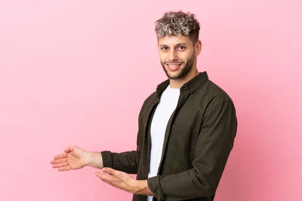Νεαρός Όμορφος Καυκάσιος Άντρας Απομονωμένος Ροζ Φόντο Απλώνει Χέρια Του — Φωτογραφία Αρχείου