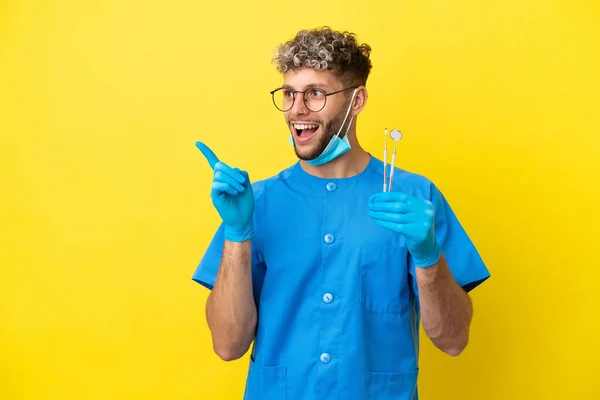 Dentista Caucasiano Homem Segurando Ferramentas Isoladas Fundo Amarelo Com Intenção — Fotografia de Stock
