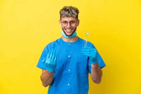 Dentysta Biały Mężczyzna Trzyma Narzędzia Odizolowane Żółtym Tle Zapraszając Ręki — Zdjęcie stockowe