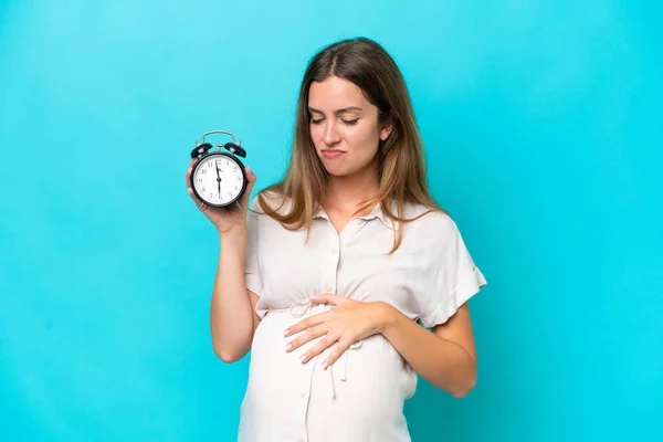 Mladá Běloška Žena Izolované Modrém Pozadí Těhotné Drží Hodiny Stresujícím — Stock fotografie