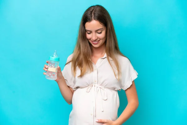 Young Caucasian Woman Isolated Blue Background Pregnant Holding Feeding Bottle — Stockfoto