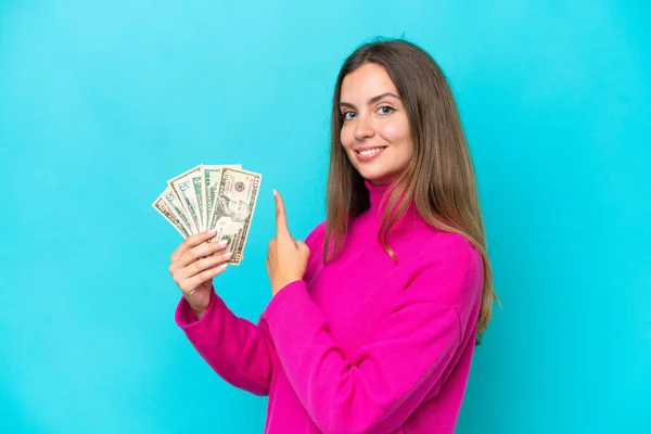 Νεαρή Καυκάσια Γυναίκα Παίρνει Πολλά Χρήματα Απομονωμένη Μπλε Φόντο Δείχνοντας — Φωτογραφία Αρχείου