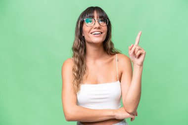 İzole edilmiş arka planda genç beyaz kadın yukarı ve şaşırmış