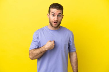 Sarışın yakışıklı, izole edilmiş sarı arka planda. Kendini işaret ediyor.