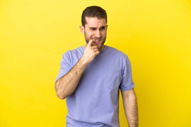 Sarışın yakışıklı adam izole edilmiş sarı arka plan gergin ve korkmuş.