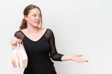 Beyaz arka planda bale yapan genç bir kadın. Sürpriz bir ifadeyle yan yana bakarken.