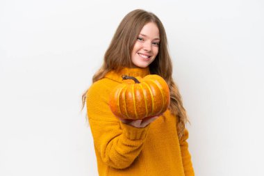 Beyaz arka planda izole edilmiş bir balkabağı tutan güzel bir kadın. Mutlu bir ifadeyle.