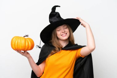 Beyaz arka planda izole edilmiş bir balkabağı tutan cadı kostümü. Çok gülümsüyor.