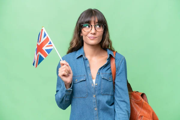 Mladá Běloška Drží Britskou Vlajku Nad Izolovaným Pozadím Dívá Nahoru — Stock fotografie