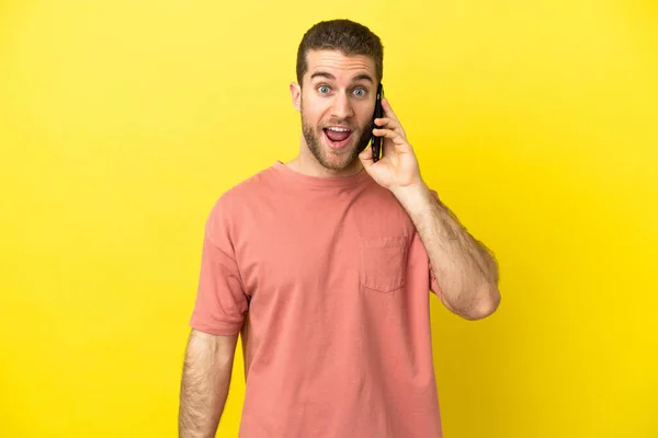 Handsome Blonde Man Using Mobile Phone Isolated Background Surprise Facial — Stock fotografie