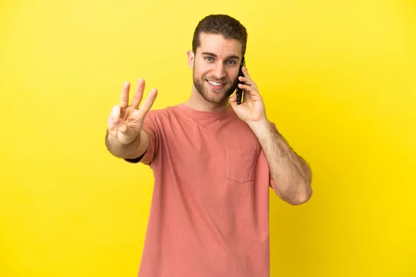 Handsome Blonde Man Using Mobile Phone Isolated Background Happy Counting — Stock Photo, Image