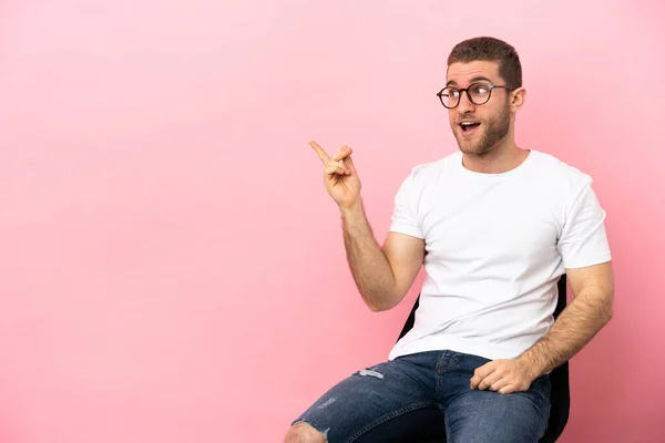 Young Man Sitting Chair Isolated Pink Background Intending Realizes Solution — Stock fotografie