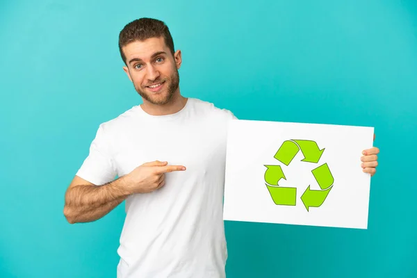 Handsome Blonde Man Isolated Blue Background Holding Placard Recycle Icon —  Fotos de Stock