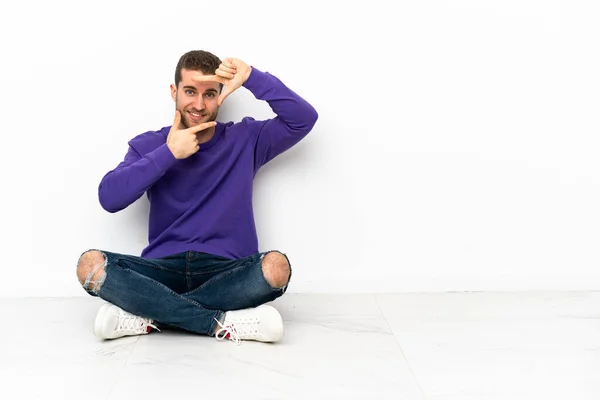 若い男の顔に焦点を当てて床に座って フレーミングのシンボル — ストック写真