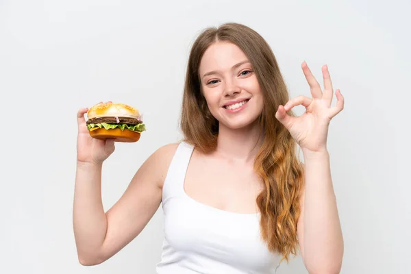 Молода Красива Жінка Тримає Бургер Ізольовано Білому Тлі Показуючи Знак — стокове фото