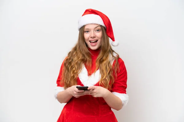 身穿白色背景孤立圣诞礼服的年轻的高加索女人感到惊讶 并发出了一个信息 — 图库照片