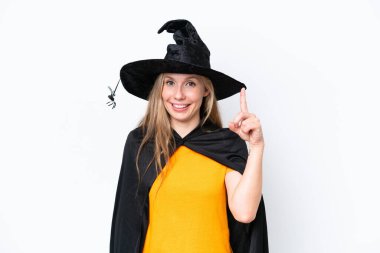 Cadı gibi giyinmiş genç sarışın kadın beyaz arka planda izole edilmiş ve en iyinin işareti olarak parmağını kaldırıyor.