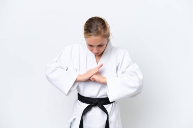Beyaz arka planda karate yapıp selam veren beyaz bir kadın.