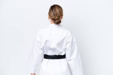 Beyaz arka planda karate yapan beyaz tenli genç bir kadın.