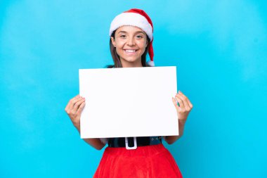 Anne Noel gibi giyinmiş genç İspanyol kadın beyaz arka planda izole edilmiş, elinde mutlu bir ifadeyle boş bir levha tutuyor.