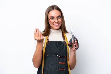 Beyaz arka planda izole edilmiş genç terzi kadın para hareketi yapıyor.