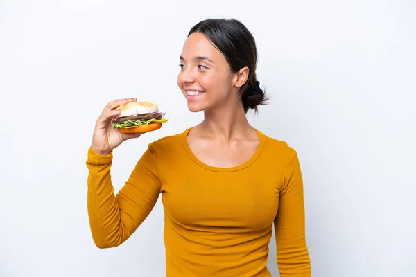 Junge Hispanische Frau Hält Einen Burger Isoliert Auf Weißem Hintergrund — Stockfoto