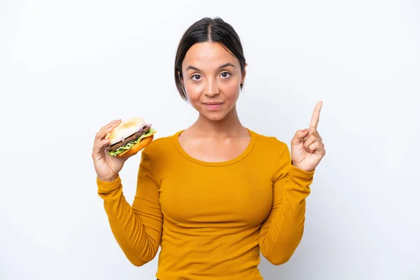 Młoda Latynoska Trzyma Hamburgera Białym Tle Wskazując Świetny Pomysł — Zdjęcie stockowe