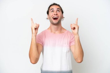 Beyaz arka planda izole edilmiş beyaz, yakışıklı bir adam şaşırmış ve yukarı bakıyor.
