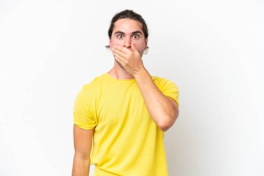 Beyaz arka planda izole edilmiş beyaz tenli yakışıklı bir adam ağızı eliyle kapatıyor.