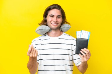 Şişirilebilir Seyahat Yastığı olan yakışıklı adam para hareketi yapıyor.