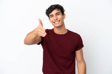 Beyaz arka planda izole edilmiş genç Arjantinli adam iyi bir anlaşma için el sıkışıyor.