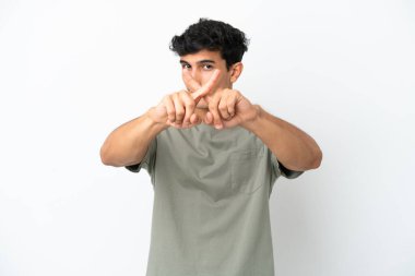 Beyaz arka planda izole edilmiş genç Arjantinli bir adam bir eylemi durdurmak için eliyle jest yapıyor.