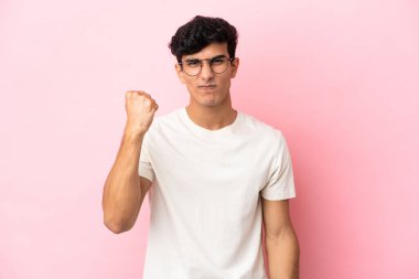 Arjantinli genç adam mutsuz bir ifadeyle pembe arka planda izole edilmiş.