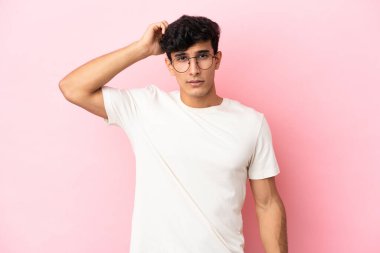 Arjantinli genç bir adam pembe arka planda izole edilmiş hayal kırıklığıyla dolu ve anlamayan