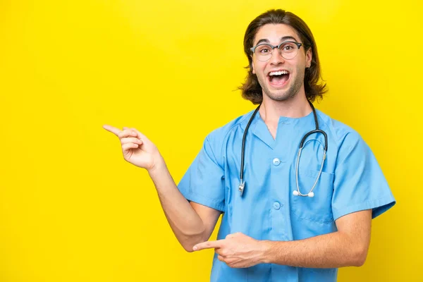 Young Surgeon Caucasian Man Isolated Yellow Background Surprised Pointing Side — Stock Photo, Image