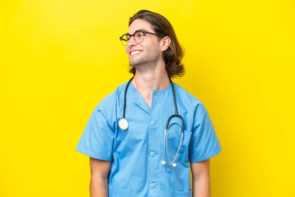 Young Surgeon Caucasian Man Isolated Yellow Background Looking Side — Stock Photo, Image