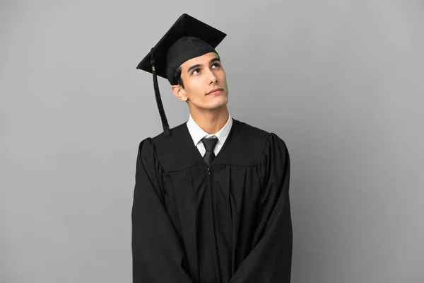 Fiatal Argentin Egyetemi Diplomás Elszigetelt Szürke Háttér Felnézett — Stock Fotó