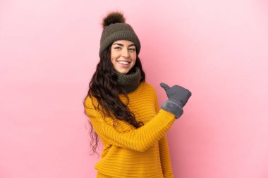 Kışlık şapkalı genç beyaz kız mor arka planda soyutlanmış gururlu ve kendini beğenmiş.