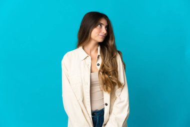 Mavi arka planda izole edilmiş beyaz bir kadın. Taraf ararken şüphe duyuyor.