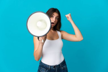 Mavi arka planda izole edilmiş beyaz bir kadın megafonla bir şey duyurmak için bağırıyor.