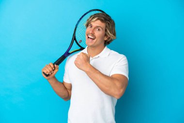 Sarışın tenisçi, mavi arka planda tek başına zaferi kutluyor.